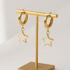 A studio shot focusing on the earrings hanging from a minimalistic display stand, with a clean, white backdrop and soft shadows to accentuate the high-shine gold plating and delicate design.