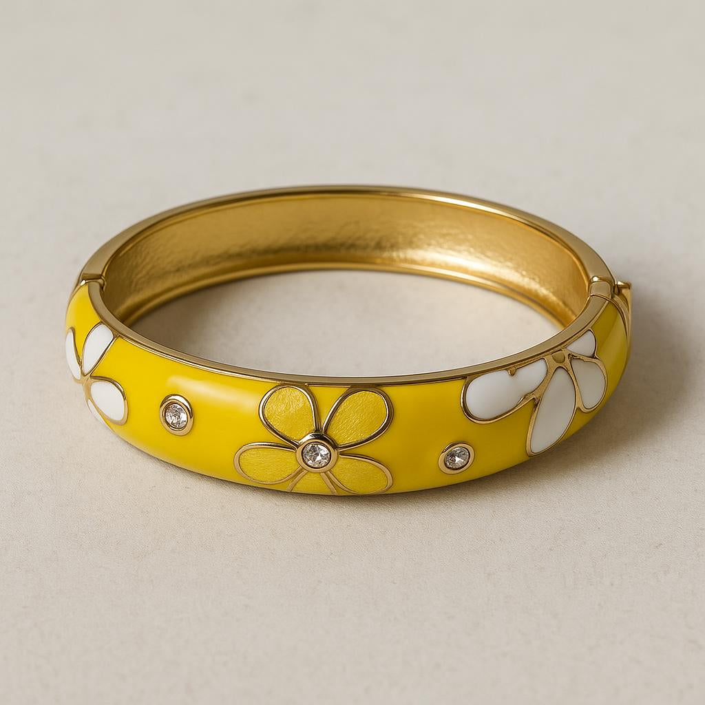 A studio shot of the bangle on a neutral, textured background, positioned to showcase the floral design, the polished inner surface, and the secure spring-hinge mechanism, with soft lighting to enhance the glossy enamel and crystal accents.